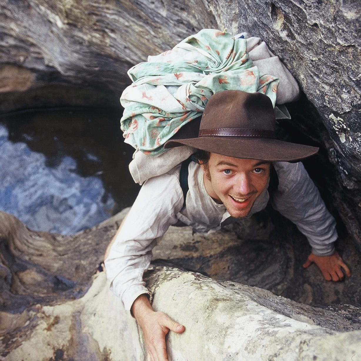 Survivalist climbs side of rocks 